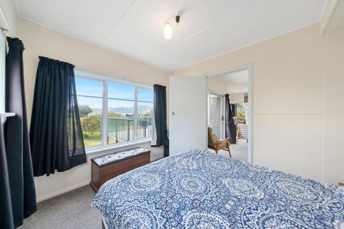 a bedroom with a bed and a window at The Green Trout - Paraparaumu Beach Holiday Home in Paraparaumu Beach