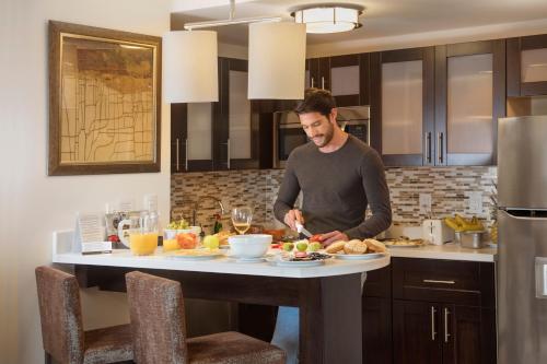 a man standing in a kitchen preparing food at Staybridge Suites - Saltillo by IHG in Saltillo