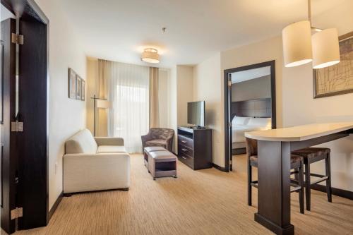 a hotel room with a desk and a living room at Staybridge Suites - Saltillo by IHG in Saltillo