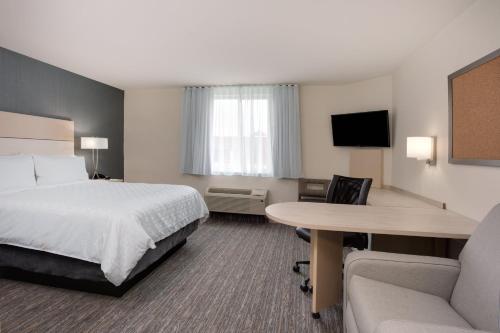 a hotel room with a bed and a table at Candlewood Suites Miami Intl Airport - 36th St by IHG in Miami