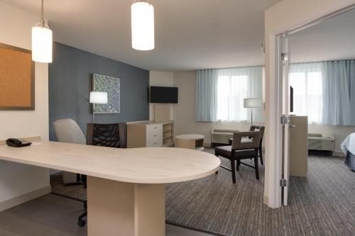 a room with a table and chairs and a bedroom at Candlewood Suites Miami Intl Airport - 36th St by IHG in Miami