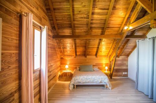 1 dormitorio con 1 cama en una casa de madera en Barbadine, en La Plaine des Cafres