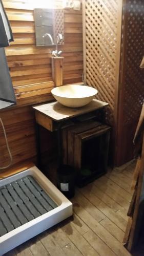 - une salle de bains avec lavabo dans une chambre dotée de murs en bois dans l'établissement La Cabane des Trappeurs, à Crépy-en-Valois