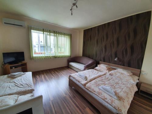 ein Schlafzimmer mit 2 Betten und einem TV. in der Unterkunft Ladik Vendégház in Tiszafüred