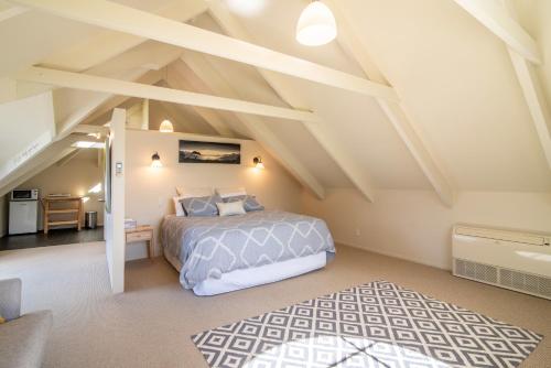 a bedroom with a bed in a attic at The Boathouse - Akaroa Holiday Home in Akaroa