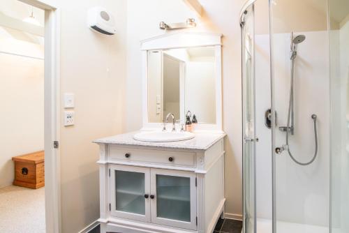 a bathroom with a sink and a shower at The Boathouse - Akaroa Holiday Home in Akaroa