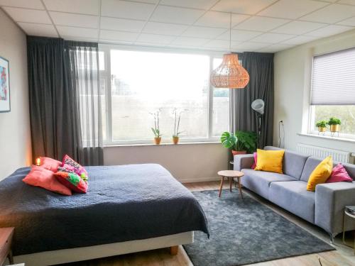 een slaapkamer met een bed en een bank bij Studio Brinkstraat in Hoogeveen