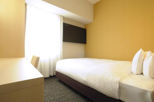 a hotel room with a bed and a window at AB Hotel Omihachiman in Omihachiman