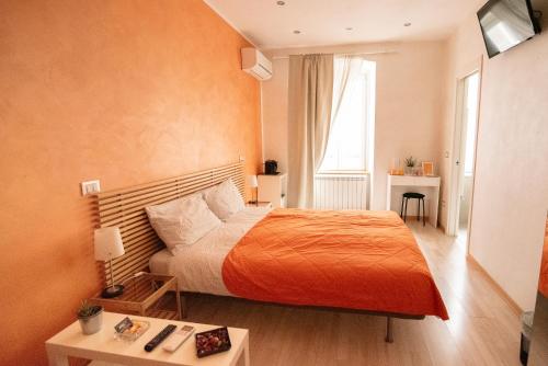 - une chambre avec un lit et une couverture orange dans l'établissement Area39, à Trieste
