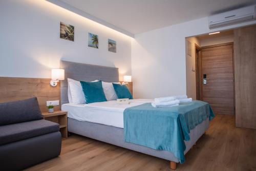 a hotel room with a bed and a couch at Mediteran Maradiso Hotel by Aminess in Crikvenica