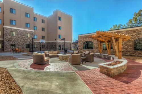 a patio with furniture and a wooden pergola at Staybridge Suites St Louis - Westport by IHG in Maryland Heights