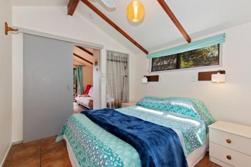 een slaapkamer met een bed en een raam bij The Stables Wairoro Park - Russell Holiday Home in Russell