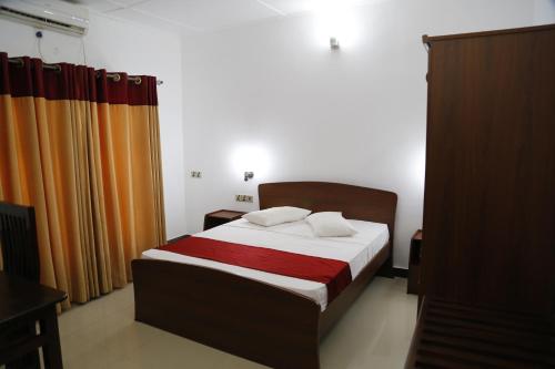 a bedroom with a bed and a curtain at Ananthi HOTELS in Vavuniya