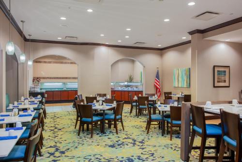 a dining room with tables and chairs and a flag at Holiday Inn Hotel & Suites Tallahassee Conference Center North by IHG in Tallahassee