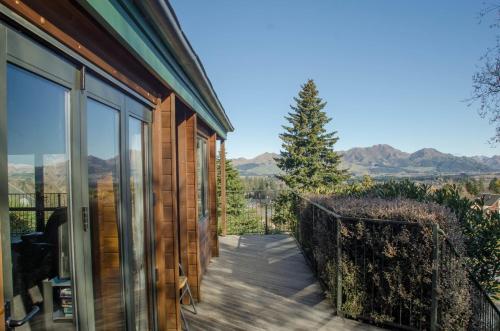 a house with a balcony with a view of the mountains at Alpine on Oregon in Hanmer Springs