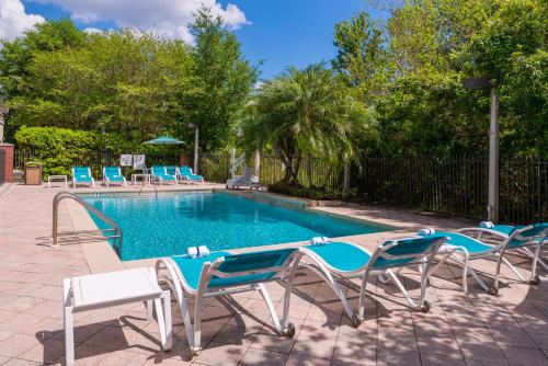a swimming pool with lounge chairs and a swimming pool at Holiday Inn Express Hotel & Suites Tampa-Anderson Road-Veterans Exp by IHG in Tampa