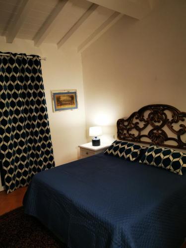 a bedroom with a bed with a blue comforter at B&B Luna Nuova in Sarzana