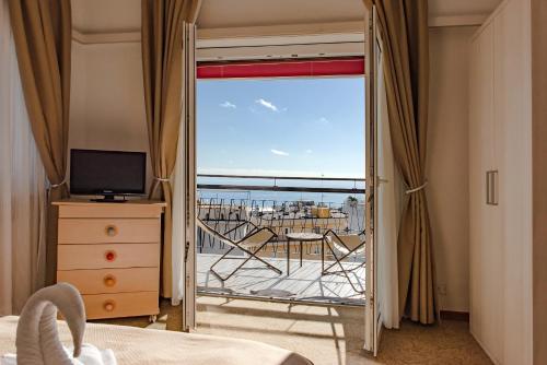 a bedroom with a view of the ocean from a balcony at Hotel Principe in Sanremo