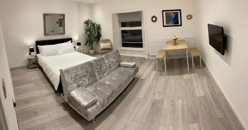 a bedroom with a couch and a bed and a television at Maryport House in Maryport