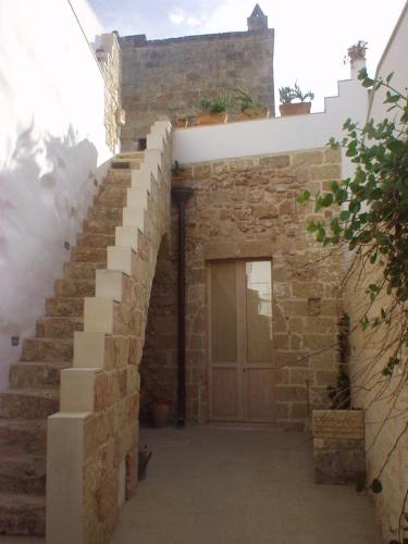 a set of stairs leading to a door in a stone building at Corte Dei Nonni in Presicce
