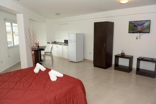 a bedroom with a red bed with white towels on it at Apart del Convento in Salta