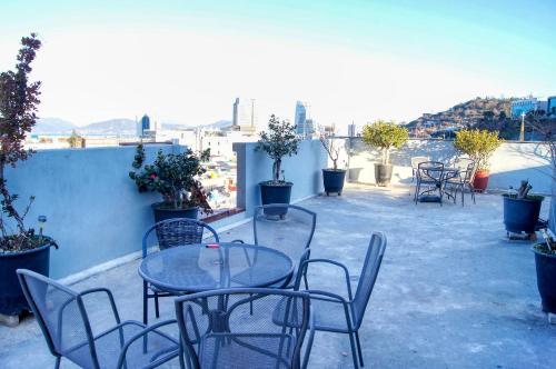 a table and chairs on a patio with a view at Backpackers In Yeosu in Yeosu