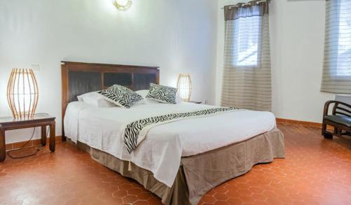 sypialnia z dużym łóżkiem z poduszkami zebry w obiekcie Appartement de Charme w Aix-en-Provence