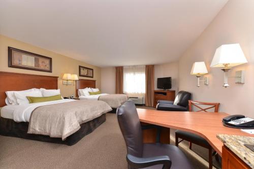 Habitación de hotel con 2 camas y escritorio en Candlewood Suites Williston, an IHG Hotel, en Williston