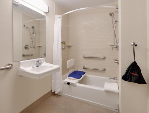 a bathroom with a sink and a tub and a toilet at Candlewood Suites Salina by IHG in Salina