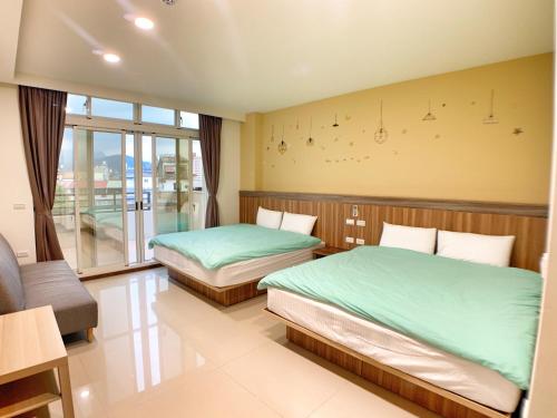 a bedroom with two beds and a large window at The Sunny Homestay in Puli