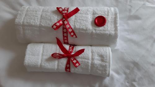 una pila de toallas blancas con lazos rojos en Hotel Post Cunter Biancardi, en Savognin
