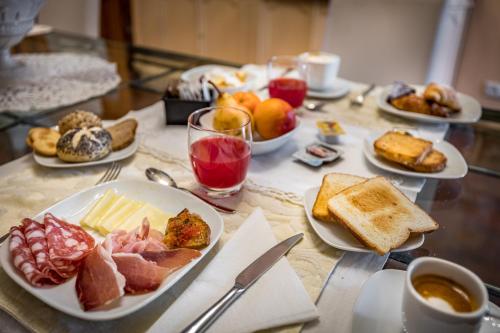 a table with plates of breakfast foods and drinks at Dimora Bandinelli in Florence