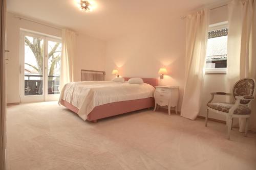 1 dormitorio blanco con 1 cama y 1 silla en Alpenjuwel, en Garmisch-Partenkirchen