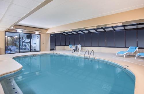 a large swimming pool in a hotel room with blue chairs at Holiday Inn Express & Suites Alcoa Knoxville Airport by IHG in Alcoa