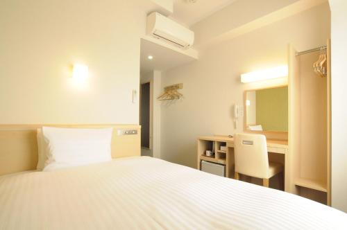 a bedroom with a bed and a desk and a mirror at AB Hotel Tokai Otagawa in Tokai