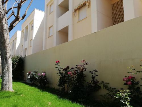 a wall with flowers in front of a building at Solmar II Solo Familias Serviplaya in Playa de Xeraco