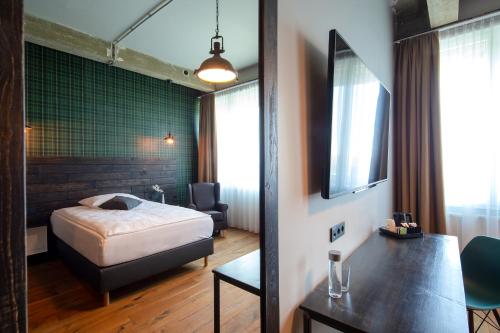 a bedroom with a bed and a table and a chair at LOFTSTYLE Hotel Hannover, Best Western Signature Collection in Hannover