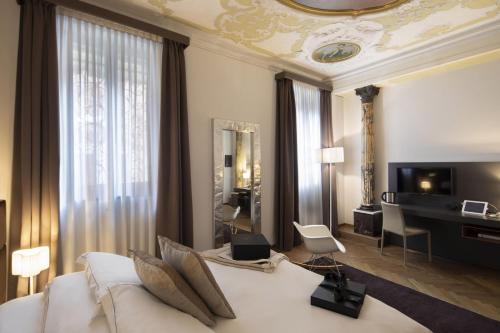 una camera con un grande letto bianco e un soggiorno di Corte Di Gabriela a Venezia