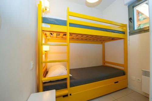 Goélia Résidence Du Parc في Gonneville-sur-Honfleur: غرفة بسرير بطابقين مع سريرين في غرفة