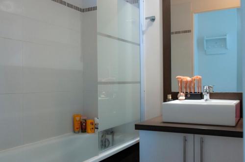 ein Badezimmer mit einem Waschbecken, einer Dusche und einer Badewanne in der Unterkunft Goélia Résidence Du Parc in Gonneville-sur-Honfleur