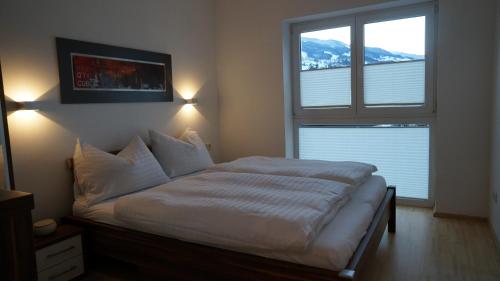 a bed in a bedroom with a large window at Appartement Silencio by Schladmingurlaub in Schladming