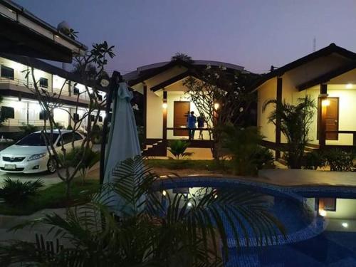 uma casa com piscina em frente a uma casa em SUNRAY Guesthouse สุนันท์บ้านพักริมคลอง em Uthai Thani