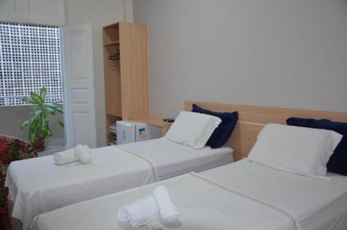 a hotel room with two beds and a window at Sumare Hotel in Florianópolis