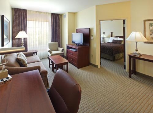 a hotel room with a bed and a living room at Staybridge Suites Hot Springs by IHG in Hot Springs