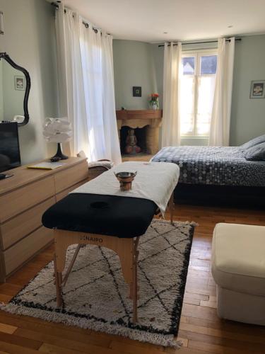 a bedroom with a bed and a table in a room at Chambre d'hôte La Bacotterie in Bois-le-Roi