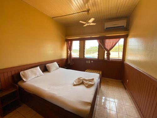 een slaapkamer met een bed en een plafondventilator bij Hotel Levy's in Bangui