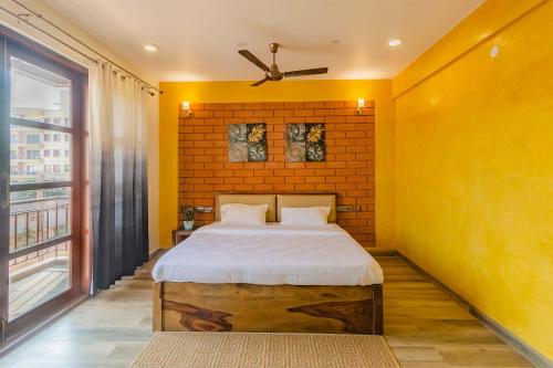 a bedroom with a bed and a brick wall at Udhbhava Kamala by VEO - Part of StayVista in Bengaluru