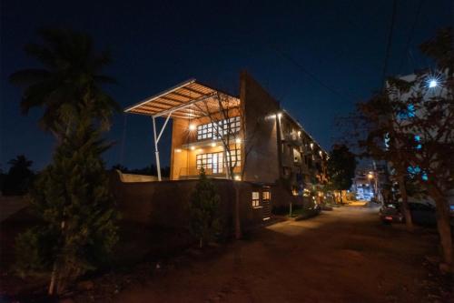 a building at night with its lights on at Udhbhava Kamala by VEO - Part of StayVista in Bengaluru
