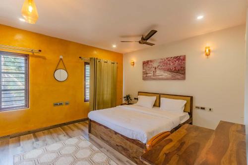a bedroom with a bed and a ceiling fan at Udhbhava Kamala by VEO - Part of StayVista in Bengaluru