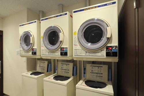 a row of washers and dryers on a shelf at AB Hotel Tokai Otagawa in Tokai